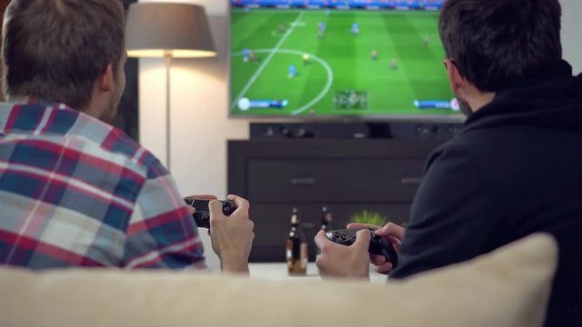 friends playing football on video game console