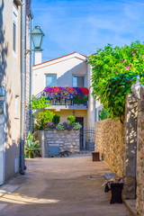 Traditional European Mediterranean architectural style in the streets and residential houses at summertime. Flowerpots stand on the stone steps.