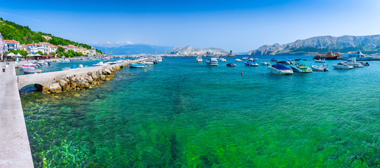 Fototapeta na wymiar Wonderful romantic summer afternoon landscape panorama coastline Adriatic sea. Boats and yachts in harbor at cristal clear turquoise water. Baska on the island of Krk.