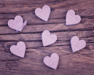 Obraz premium Purple wooden hearts on a very old wood