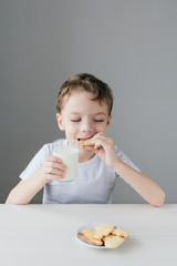 The child is happy to eat homemade biscuits with milk