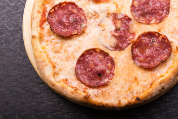 hot pepperoni pizza on wooden board