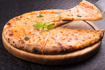 tasty and hot italian pizza with basil leaves and cheese