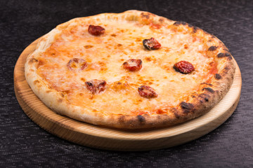 hot pepperoni pizza on wooden board