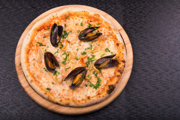 pizza with mussels and squids on wooden board