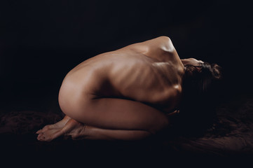 Beautiful woman over dark background, yoga posing