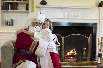 Fototapeta na wymiar Little girl giving Santa Clause a hug
