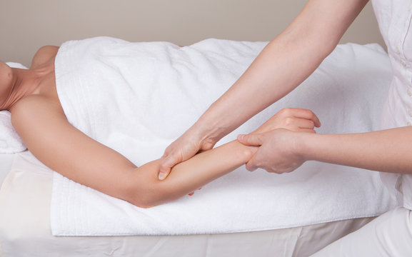 Professional  therapist doing  remedial deep tissue massage on muscles of a woman's  forearm