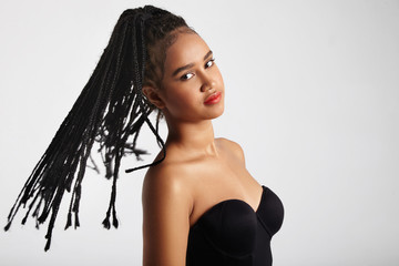 black woman shakes her head and braids are fly in air - obrazy, fototapety, plakaty