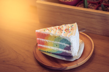Rainbow cake in wood dish on the wood table