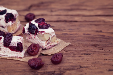 Soft nougat topped with forest fruits on rustic wood