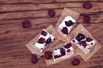 Top view of soft nougat topped with forest fruits on an old  wood