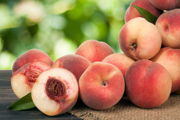 heap of peaches on a wooden table with blurred background