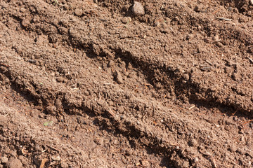 Brown dry plowed soil surface with grooves