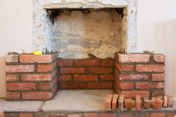 Indoor DIY project: building fireplace in the house: laying bricks. Selective focus