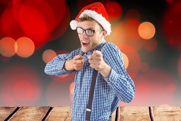 Man in santa hat gesturing against digitally generated backgroun