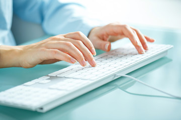 Woman office worker typing on the keyboard