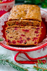 Traditional Christmas cake with dried fruits on a red plate