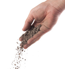 Hand sprinkling soil on white background