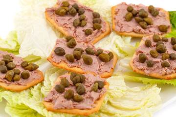 Meat pate with capers on crackers