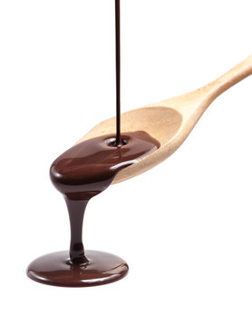 Melted chocolate poured into a spoon, isolated on the white 