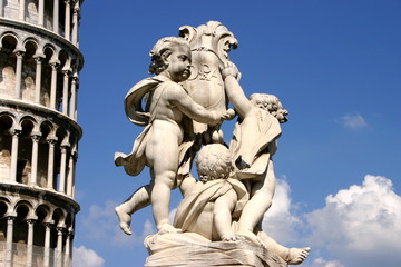 Fototapeta na wymiar Engelsstatue mit Wappenschild und Inschrift vor schiefem Turm in Pisa