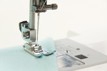 The sewing on the sewing machine turquoise fabric