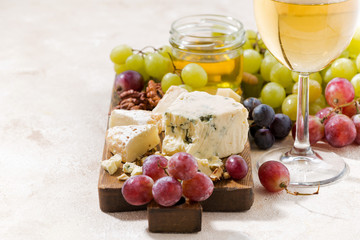 cheeseboard, grapes and wine on a white background