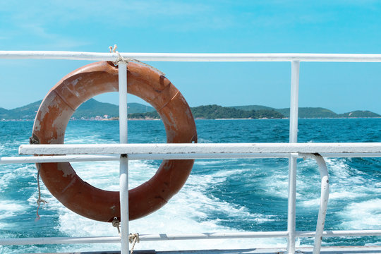 Close Up Life Ring On Back Of Boat With Blurry View Of Wave On Sea And Island. Relax And Enjoy Life Concept .