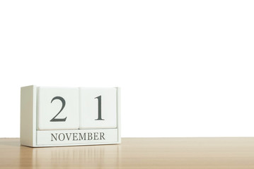 Closeup surface white wooden calendar with black 21 november word on blurred brown wood desk isolated on white background with copy space , selective focus at the calendar