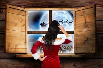 Woman in santa costume looking through window