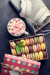 Colorful macaroons in a gift box and headphones