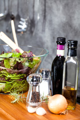 salade verte avec du vinaigre de l'huile d'olive de l'ail et des oignon sur une planche en bois