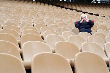 many chairs and a lone girl on stadium