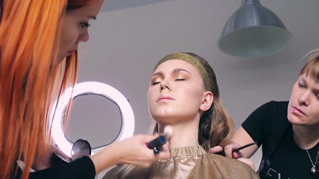 makeup artist makes models eye makeup. Hairdresser makes hairstyle for model, beauty concept, accelerated video