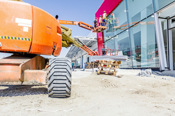 Working in elevated cherry picker on building site