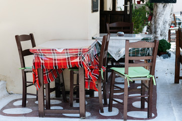 Fototapeta na wymiar Wooden table with chairs at traditional Greek cafe
