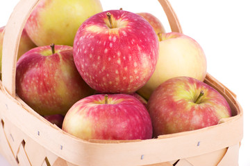 Closeup of fresh apples in a basket, on white