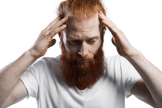 Headache. Man Keep Head By Two Hands. Depression Emotion. Thinking Moment. Close Up Portrait Of Red Head Guy. Hipster With Big Beard In Studio On White Background
