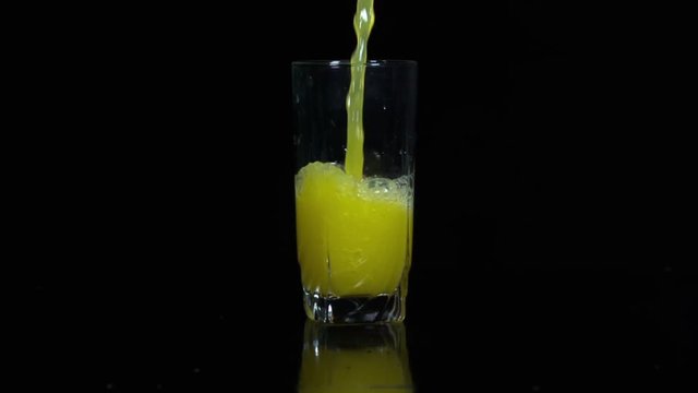 A glass of juice is poured in slow motion