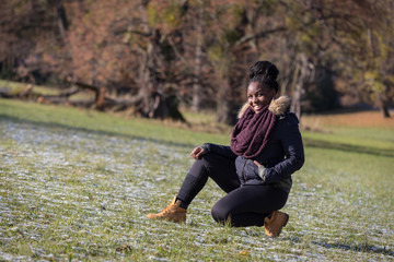 Smiling black girl wearing winter jacket in a park