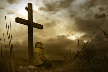 Man waiting under a christian cross. Cloudy sky background