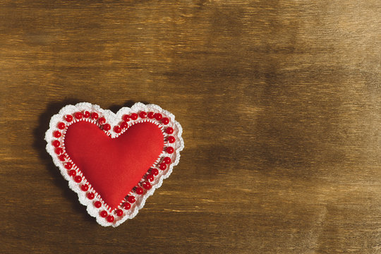 Valentine's Day background. Handwork red heart on the wooden background with place for text