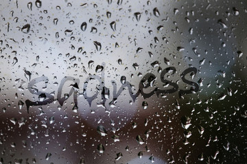 Sadness written on rainy window