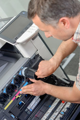 Man replacing ink in printer