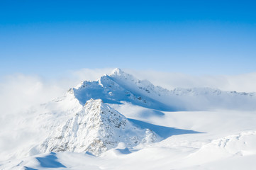 Fototapeta na wymiar Snow-covered mountains and blue sky