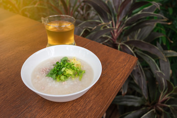 Pork porridge with ginger and coriander in bowl.
