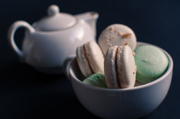 cup of tea with french macaroon on dark background.