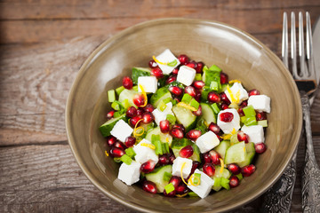 Fresh  green salad with pomegranate seeds, cucumber and feta che