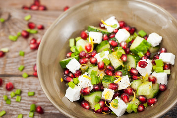 Fresh  green salad with pomegranate seeds, cucumber and feta che